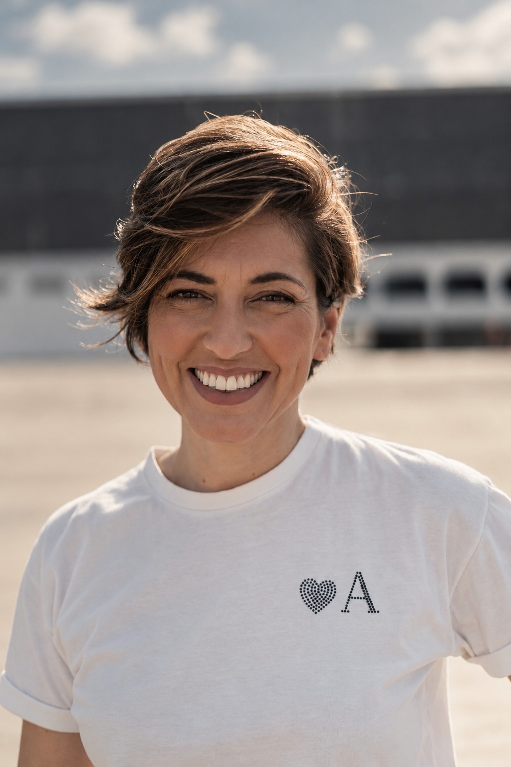 Alline sorrindo, de frente, olhando para a câmera